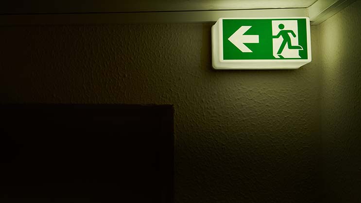 an emergency light with an arrow, in a dark room showing someone where to go