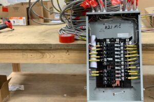 A homeowner's workbench attempting a DIY electrical panel replacement.